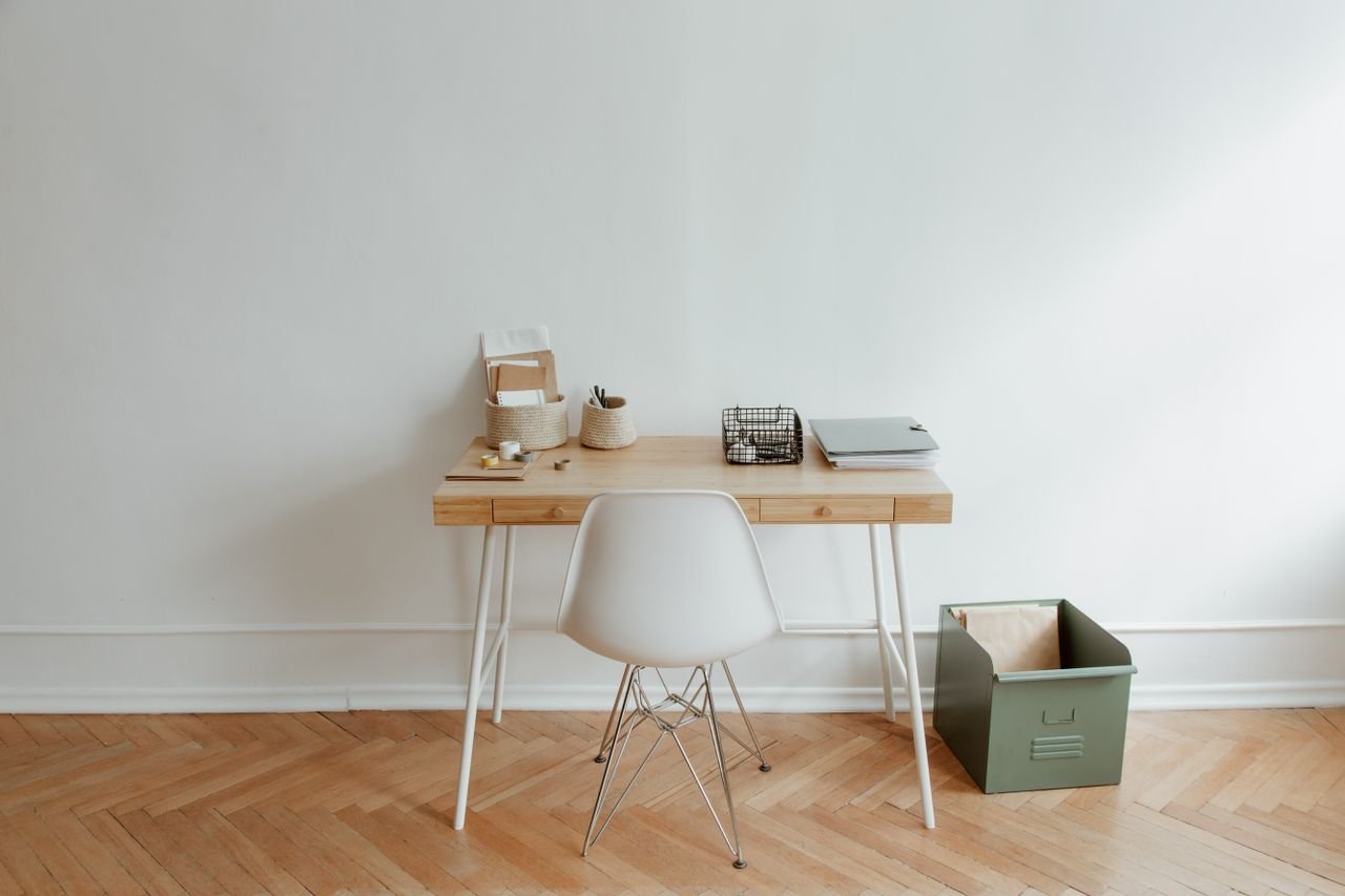about-img A minimalist home office setup with a wooden desk and a white chair, offering a clean and simple aesthetic.